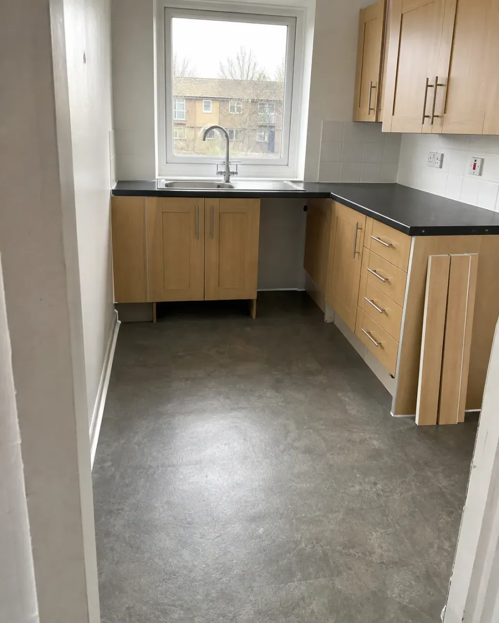 A bare kitchen scrubbed after pest control, kickboards removed and leaning ready to refit